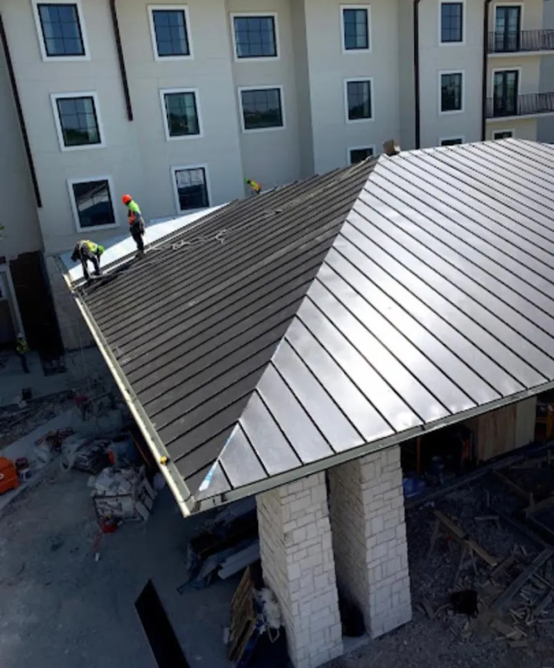 Crew installing standing seam metal roof panels on a commercial project in Punta Gorda